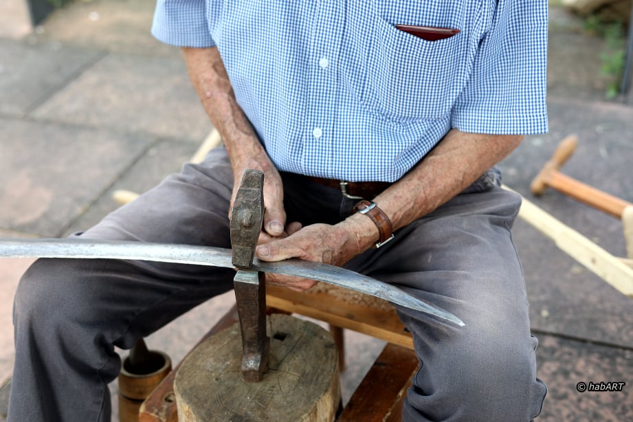 Hände die das Sensendengeln zeigen