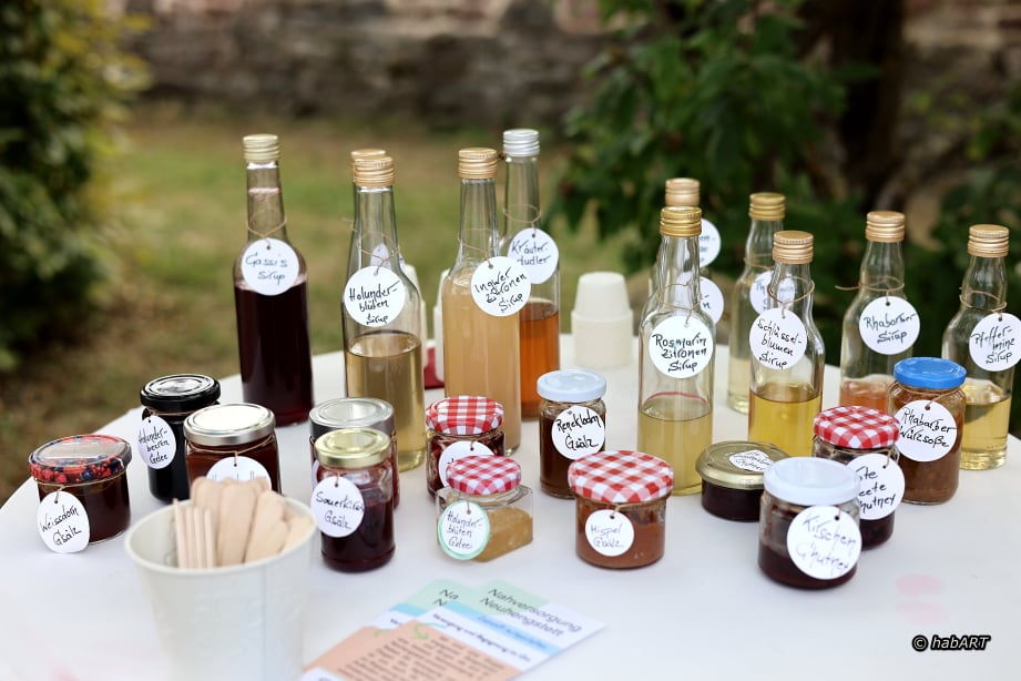 Flaschen mit Sirup und Marmeladen zum Probieren