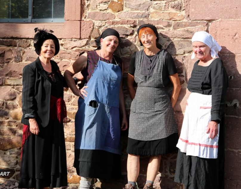 Frauen posieren an der Kirchenmauer.