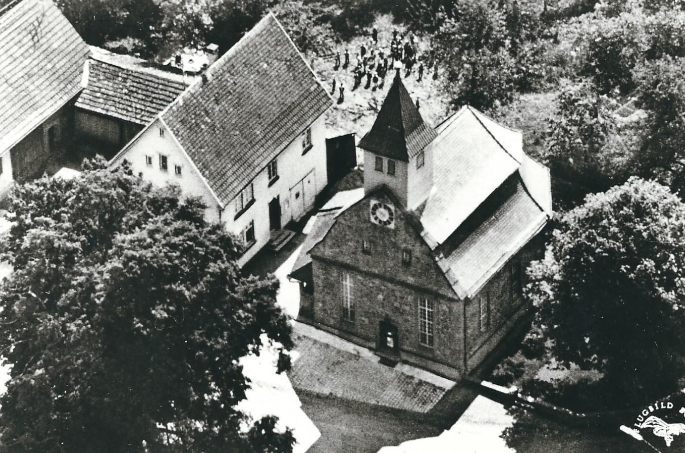 Historisches Luftbild von Kirche und Rathaus. Link führt zu einem Bild mit dem neuen Ortschild für Neuhengstett, 2023